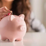 Putting coin in piggy bank
